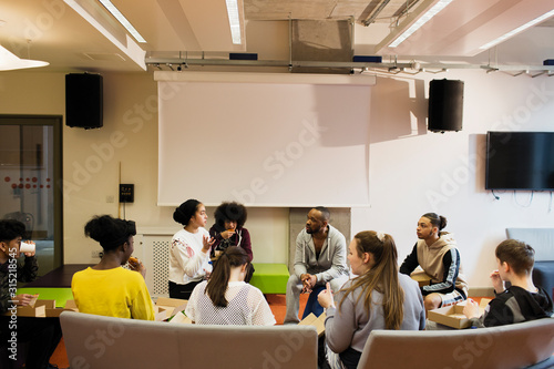 Teenagers and mentor talking in community center