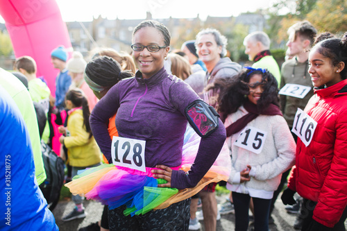 Portrait confident female runner wearing tutu at starting line at charity run
