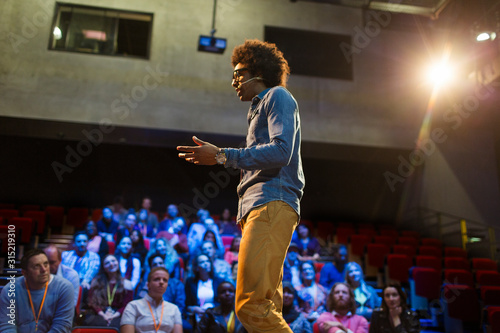 Male speaker on stage talking to audience