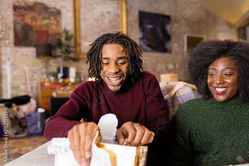 Young man opening Christmas gift