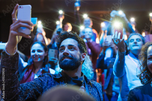 Audience using smart phone flashlights photo