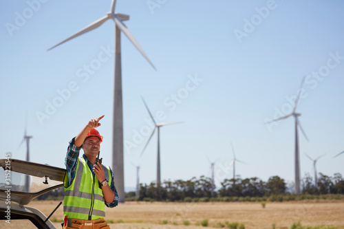 Engineer with walkie-talkie at wind turbine power plant photo