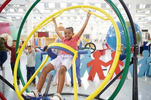 Portrait playful girl using gyroscope in science center photo