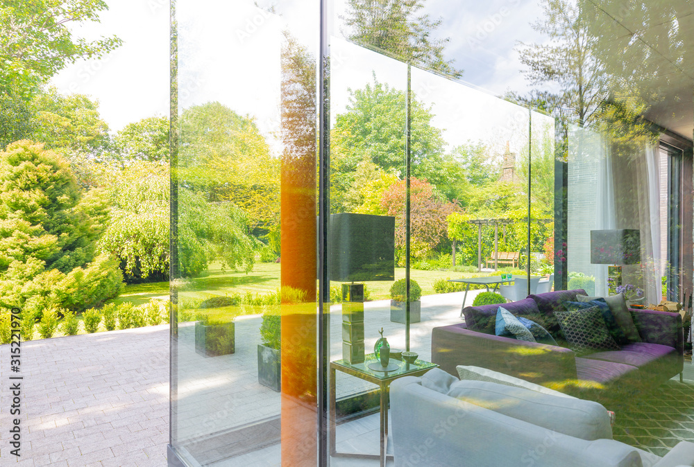Modern house with floor-to-ceiling windows and landscaped yard Modern house with floor-to-ceiling windows and landscaped yard