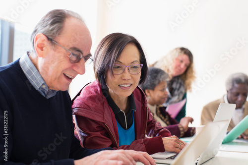 Senior business people using laptop in conference room meeting photo