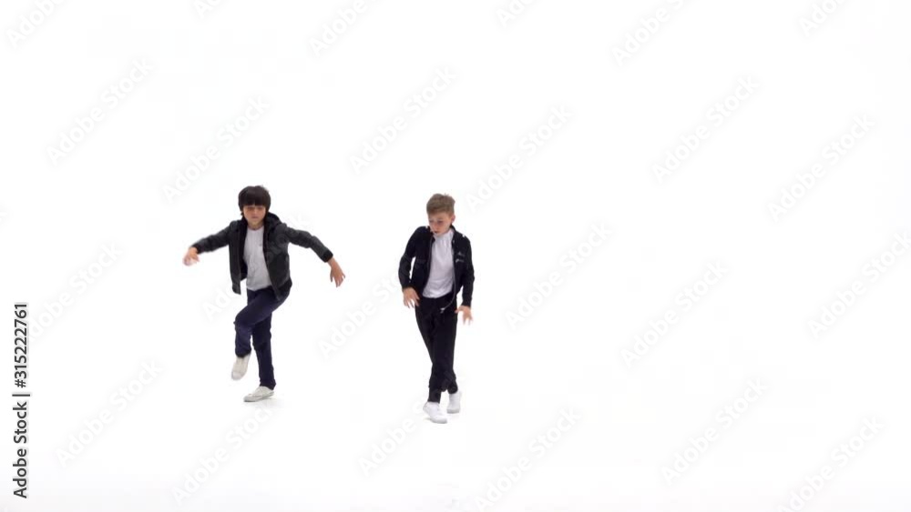 Little boys are dancing a modern dance on the white background in black leather jackets and jeans. Slow motion. Little boys are dancing a modern dance on the white background in black leather jackets and jeans. Slow motion.