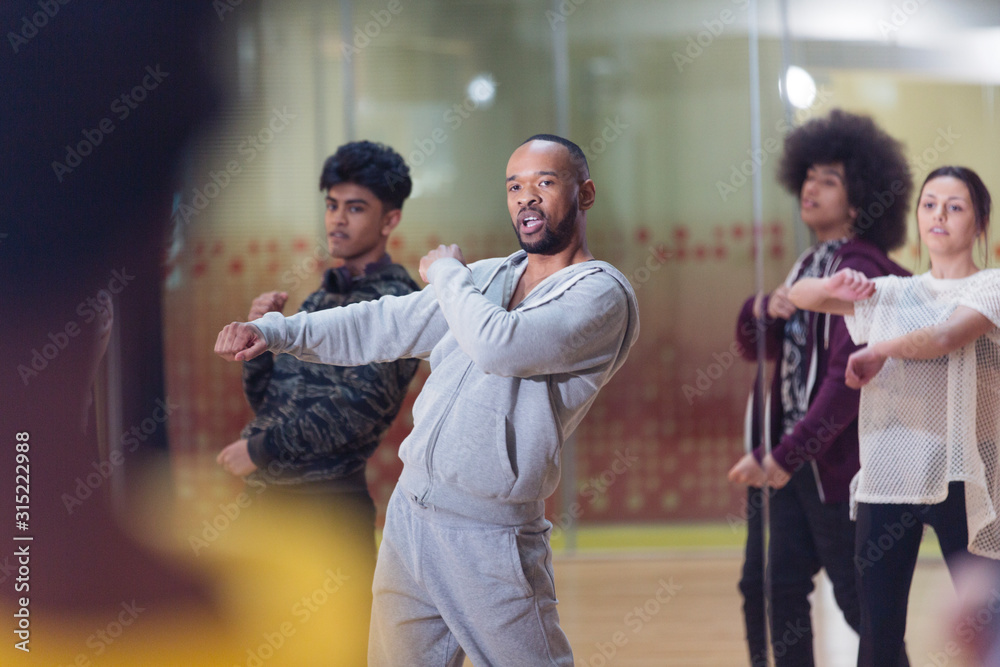 Male instructor leading dance class in studio Male instructor leading dance class in studio