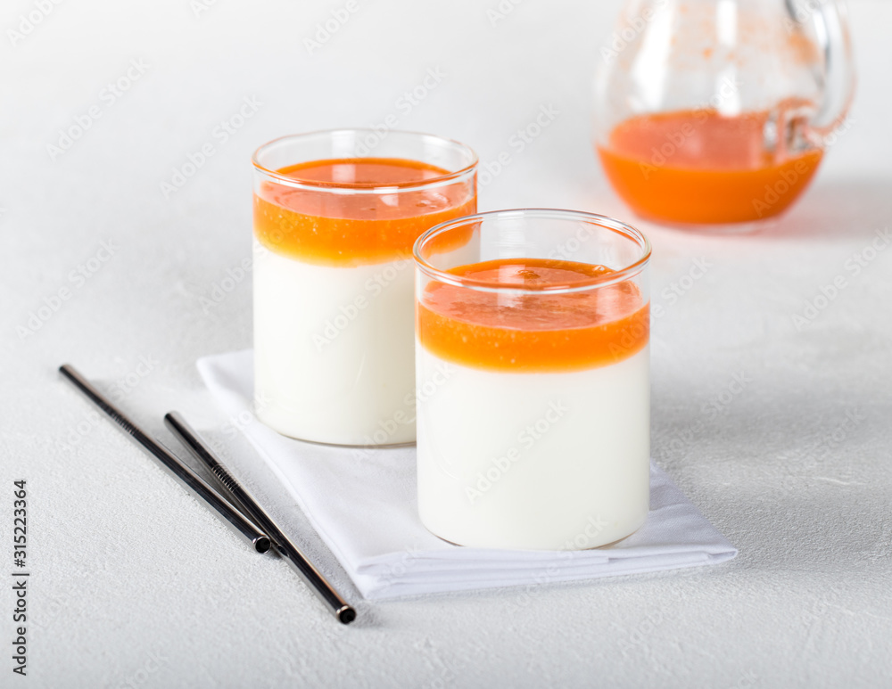 Fermented milk drink with carrot juice and sea buckthorn on a light background