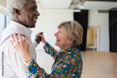 Happy active senior couple dancing in dance studio