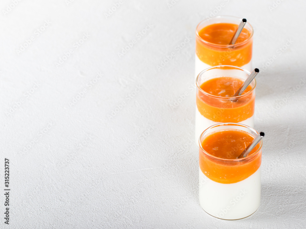 Fermented milk drink with carrot juice and sea buckthorn on a light background Fermented milk drink with carrot juice and sea buckthorn on a light background