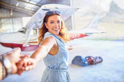 Personal perspective eager woman leading man by the htoward small airplane