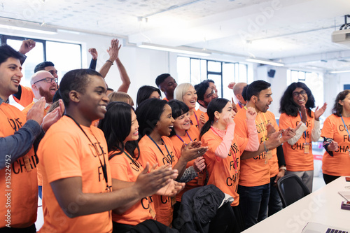 Happy hackers cheering celebrating, coding for charity at hackathon photo