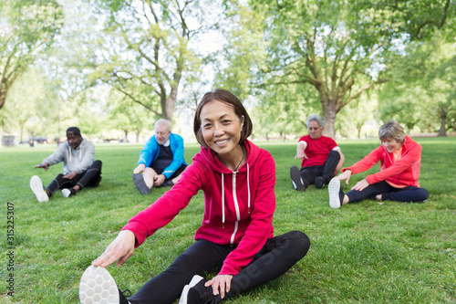 Portrait smiling, confident active senior woman stretching in park