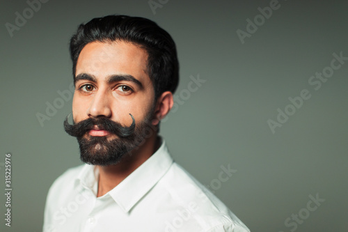 Portrait confident young man with handlebar mustache photo