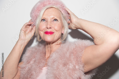 Portrait confident, glamorous senior woman wearing pink fur photo