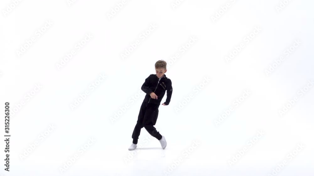 Little boy is dancing a modern dance on the white background in black leather jackets and jeans. Slow motion. Little boy is dancing a modern dance on the white background in black leather jackets and jeans. Slow motion.
