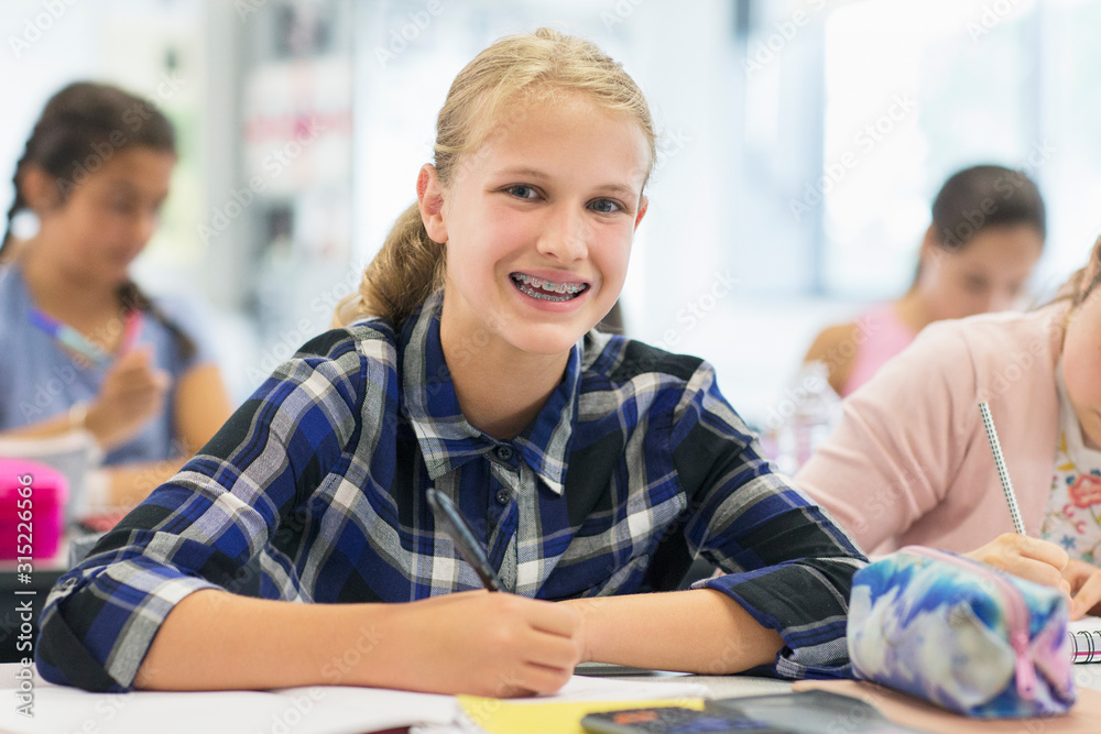 Portrait smiling, enthusiastic junior high school girl student braces in classroom Portrait smiling, enthusiastic junior high school girl student braces in classroom