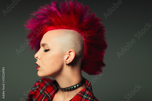 Profile portrait cool young woman with pink mohawk photo