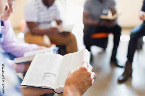 Men reading and discussing bible in prayer group photo