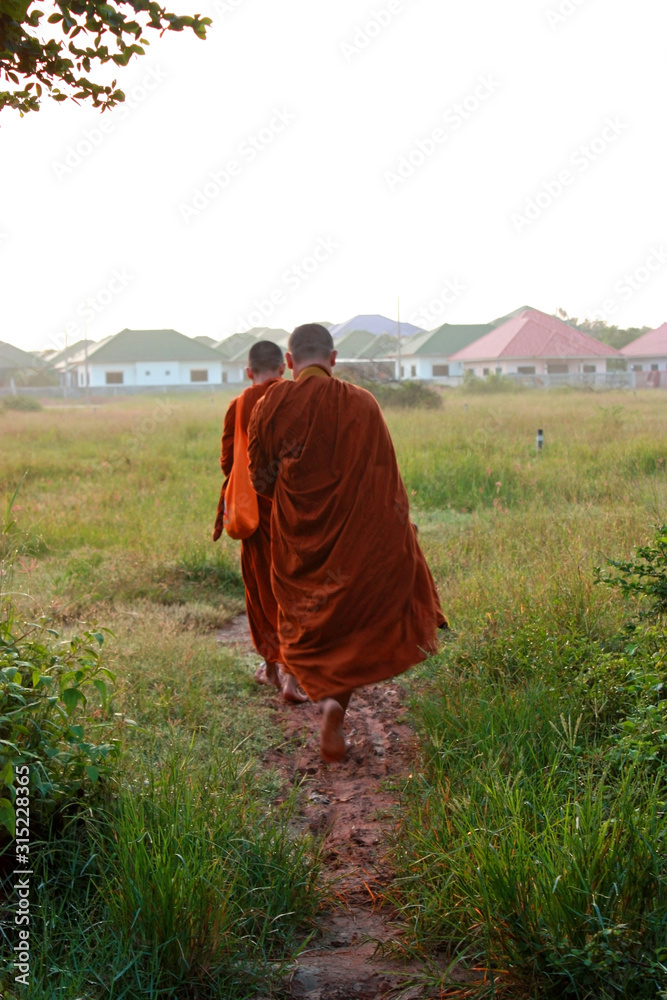 Monk of Thailand walking around temple area for receive foods by people at morning time. Monk of Thailand walking around temple area for receive foods by people at morning time.