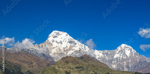 Top of the hill, covered with snow and white clouds