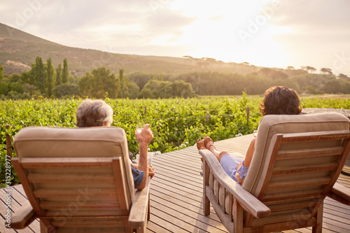 Couple relaxing, drinking wine on sunny, idyllic resort patio