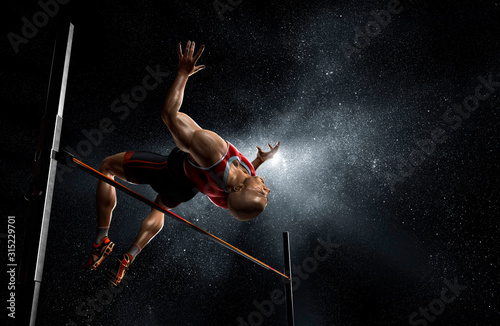 Male track and field athlete high jumping photo