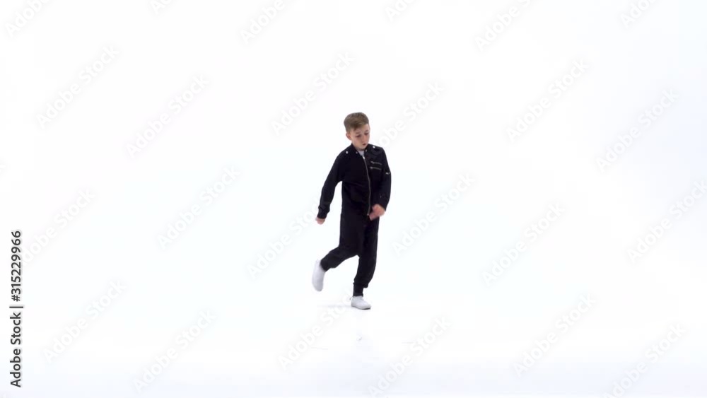 Little boy is dancing a modern dance on the white background in black leather jackets and jeans. Slow motion. Little boy is dancing a modern dance on the white background in black leather jackets and jeans. Slow motion.