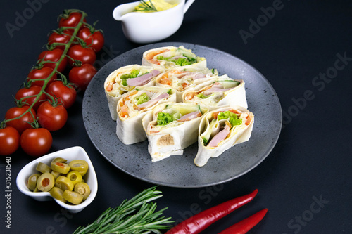 Pita on a beautiful gray plate, next to there are cherry tomatoes, rosemary, olives, and red hot pepper photo