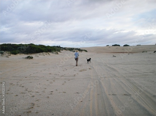 Playing with dog on sand dunes, Western Australia