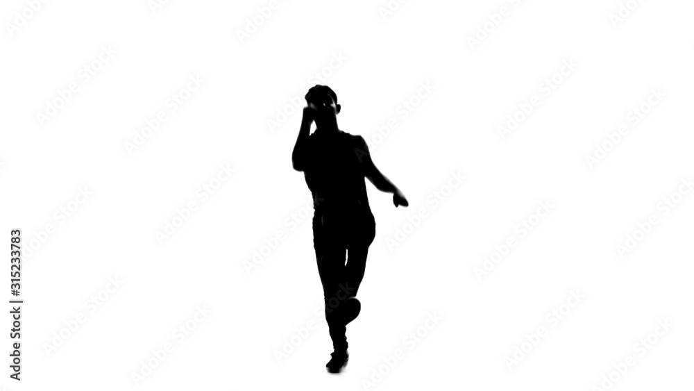 Silhouette of Man is dancing breakdance on the white background in simple grey t-shirt and grey jeans. Slow motion. Silhouette of Man is dancing breakdance on the white background in simple grey t-shirt and grey jeans. Slow motion.