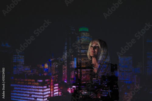 Double exposure thoughtful businesswoman against highrise lights at night photo