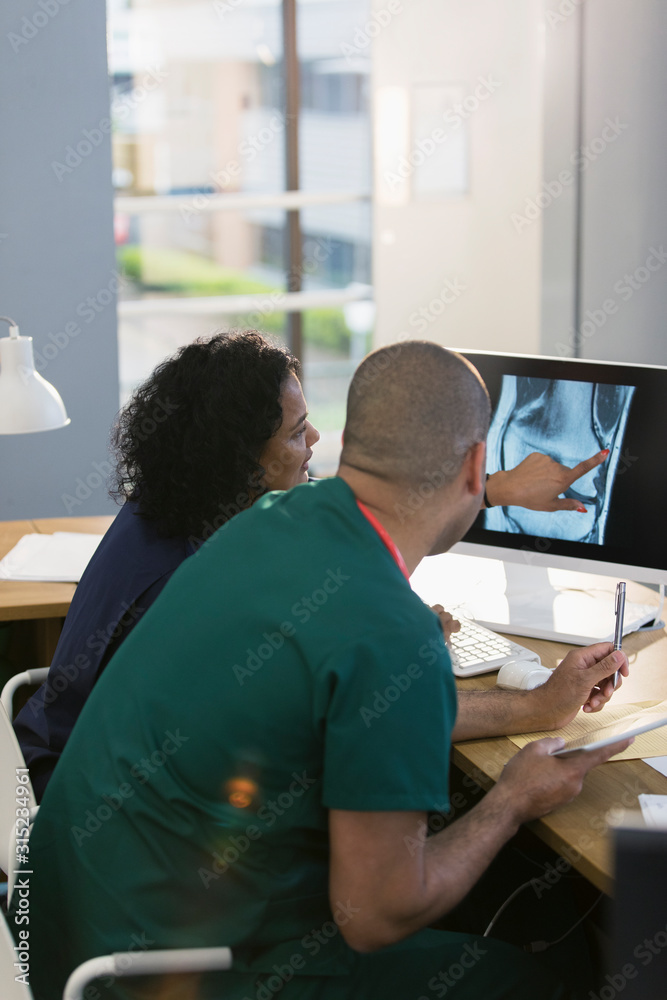 Nurses discussing digital x-ray at computer in clinic Nurses discussing digital x-ray at computer in clinic