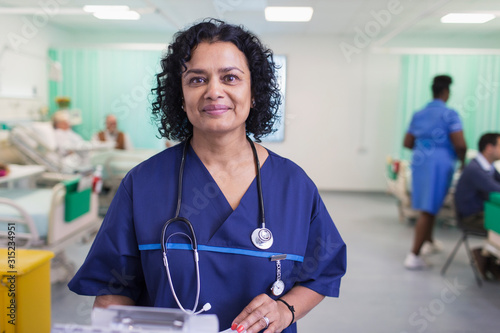 Portrait confident female doctor making rounds in hospital ward