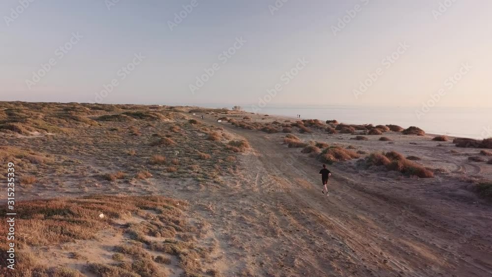Young man running in the desert landscape Young man running in the desert landscape