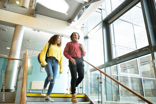 Smiling college students descending staircase