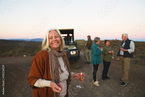 Portrait happy senior woman drinking champagne on safari photo