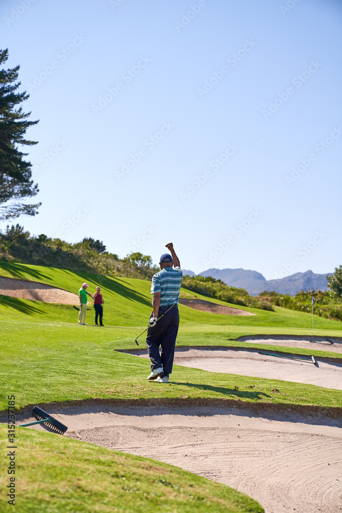 Happy man golfing cheering on sunny golf course Happy man golfing cheering on sunny golf course