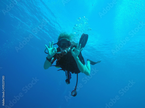 Portrait of confident scuba diver gesturing okay underwater