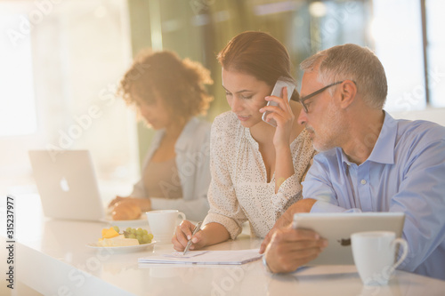 Business people drinking coffee and working at counter