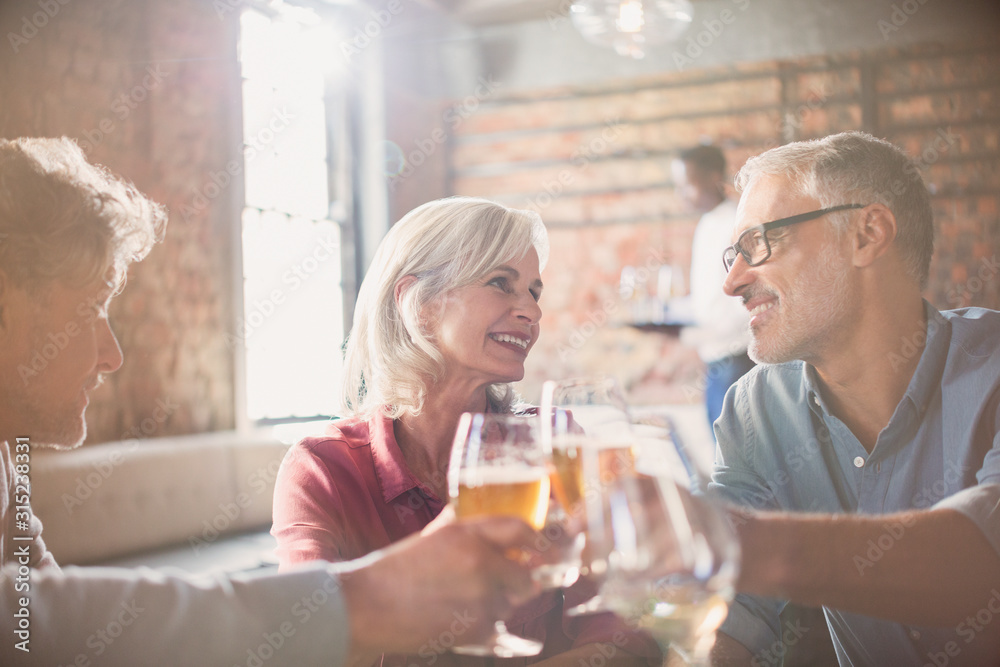 Smiling friends toasting beer and wine glasses in restaurant Smiling friends toasting beer and wine glasses in restaurant