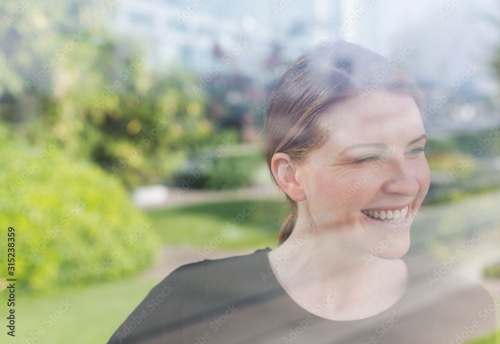 Smiling woman looking out window Smiling woman looking out window