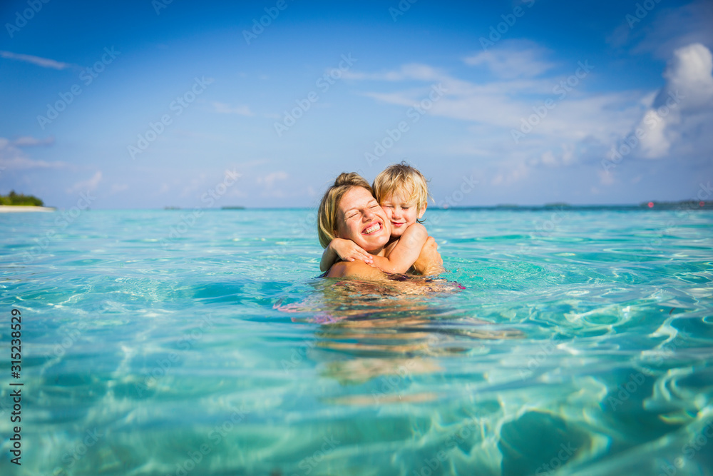 Enthusiastic mother hugging son in tropical ocean Enthusiastic mother hugging son in tropical ocean