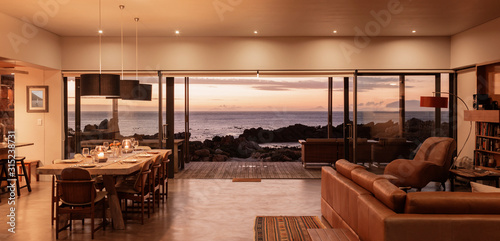 Home showcase interior overlooking ocean at sunset
