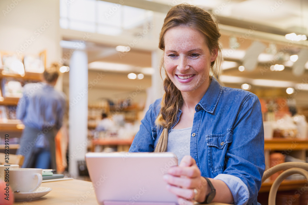 Smiling woman using digital tablet in cafe Smiling woman using digital tablet in cafe