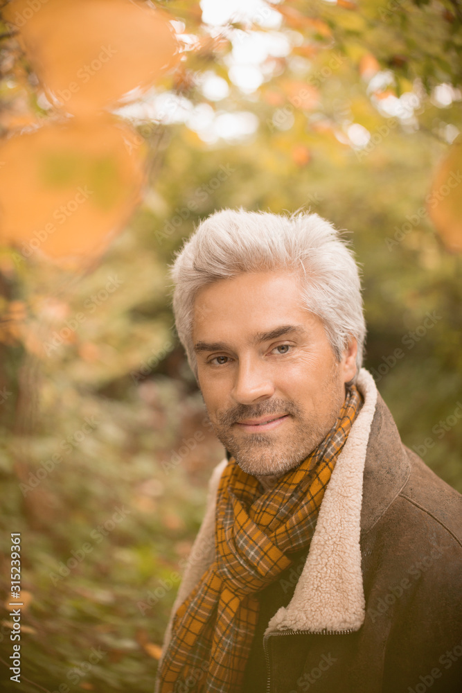 Portrait confident man wearing scarf in autumn woods Portrait confident man wearing scarf in autumn woods
