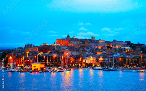 Old Sardinian Port with ships at Mediterranean Sea and city of Cagliari, South Sardinia Island in Italy in summer. Cityscape with marina and Yachts and boats in town