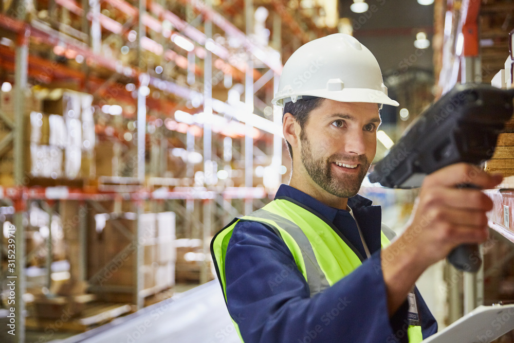 Worker using scanner in distribution warehouse Worker using scanner in distribution warehouse