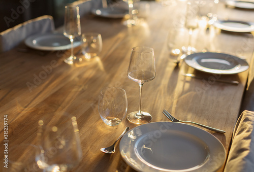 Sunny reflection on placesettings on wood dining table photo