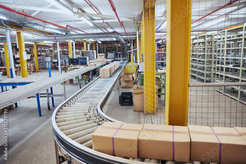 Cardboard boxes on conveyor belt in distribution warehouse